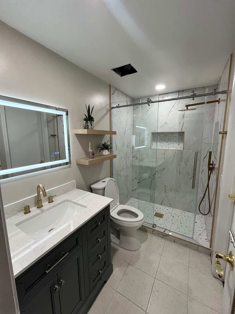 Bathroom remodel: Marble-look glass shower, brass fixtures and an LED mirror