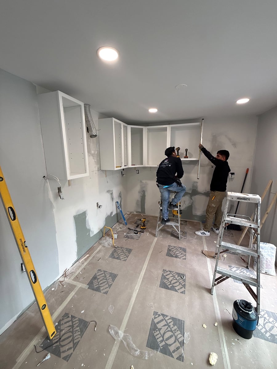 The MC Innovation crew installing kitchen cabinets