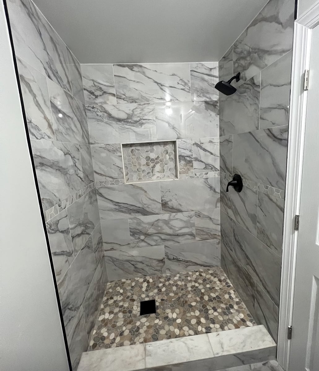 Shower remodel: Marble-look tile, a mosaic niche and a pebble floor