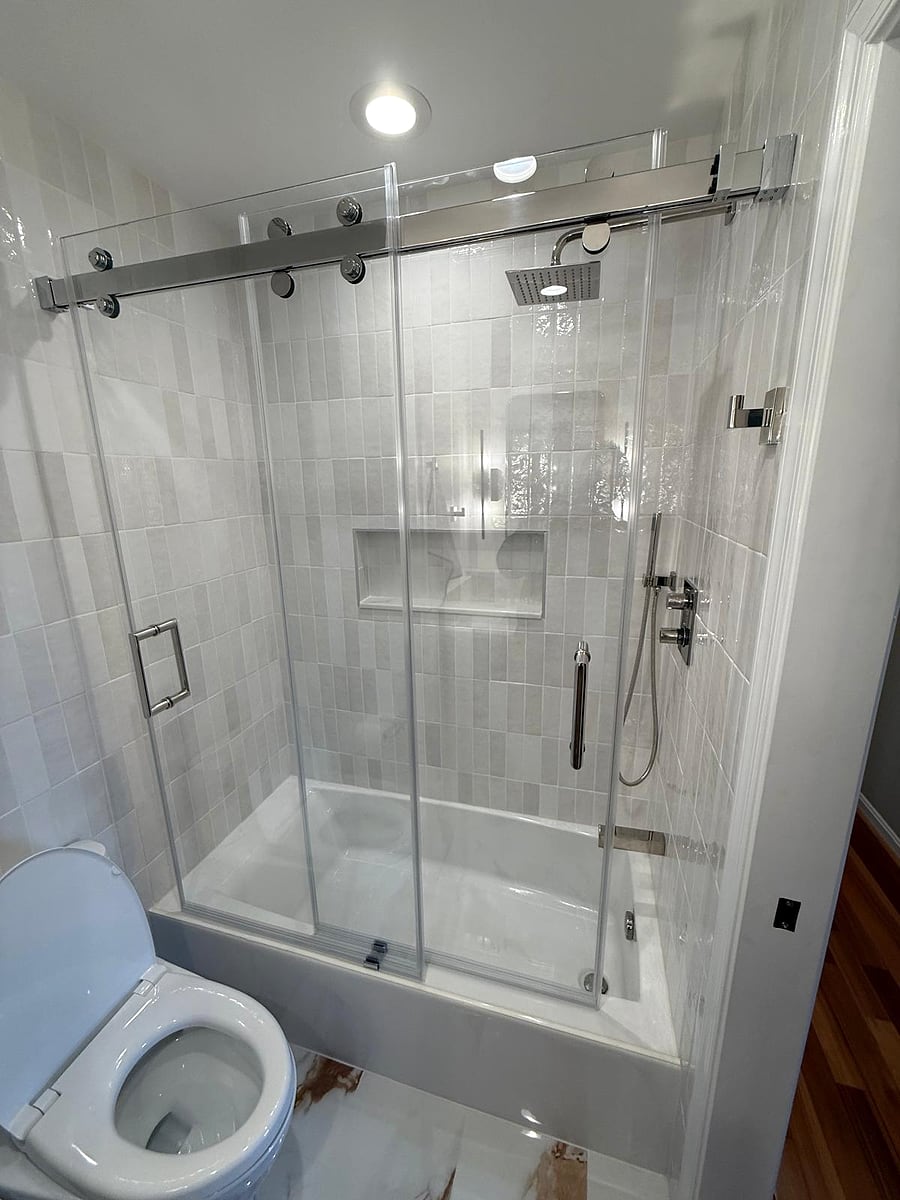 Frameless sliding glass door and stacked white tile